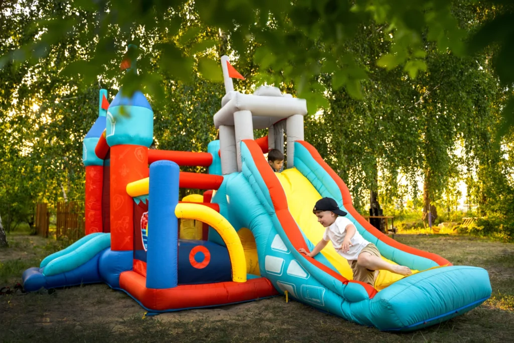 Toddlers jumping and laughing in a colorful mini bounce house indoors