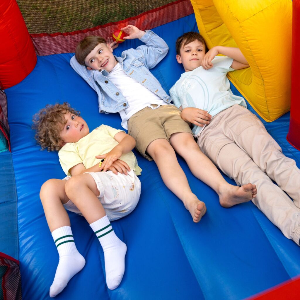 Kids playing inside a colorful inflatable bounce house rental at a party