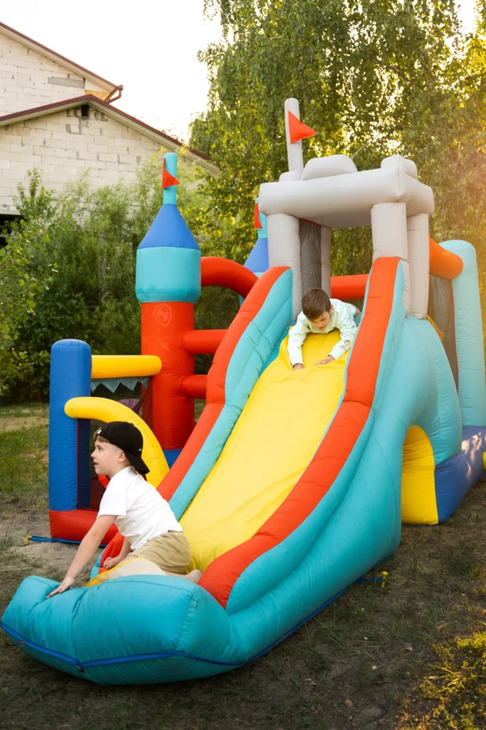 Children running and climbing on an inflatable obstacle course with a jumping castle section