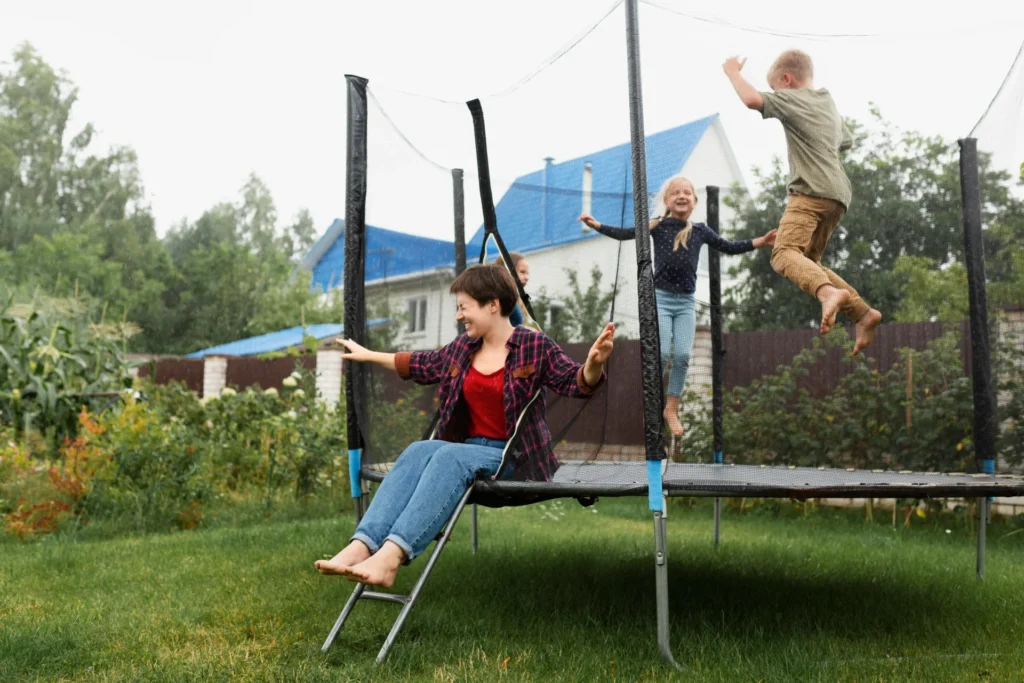 Family setting up a backyard obstacle course with a jumping castle included