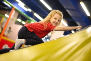 Family enjoying a bounce trampoline park with a visible closing time schedule