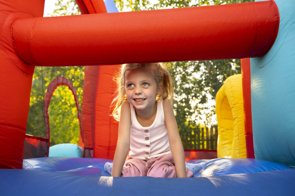 Kids enjoying colorful bounce house rentals at a backyard party