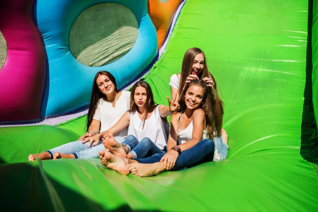 Kids and adults having fun at a bounce party with a colorful jumping castle
