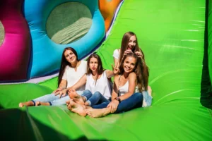 Kids and adults having fun at a bounce party with a colorful jumping castle